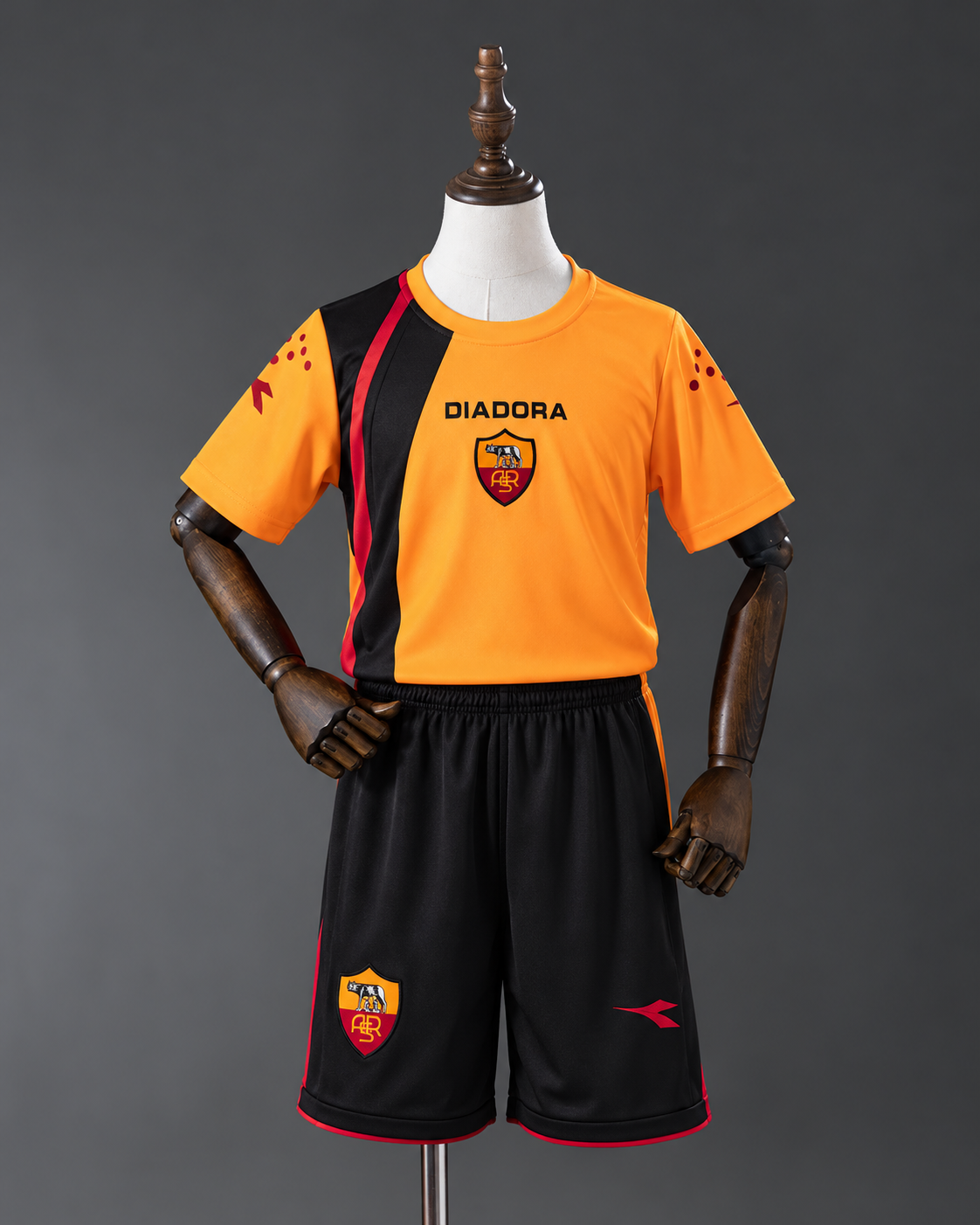 AS Roma Diadora Retro Kids Football Kit - bright orange football jersey and matching black shorts on child mannequin